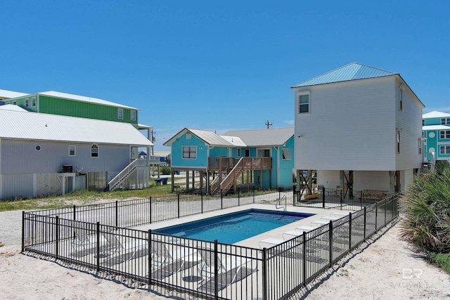 pool with stairs, a patio area, fence, and a residential view