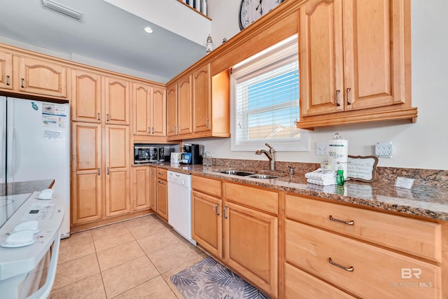 kitchen with light tile patterned floors, stone counters, white appliances, a sink, and visible vents