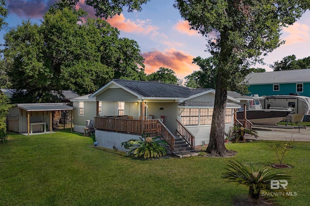 view of front of property featuring a lawn and a wooden deck