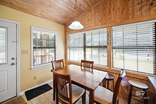 dining room featuring light hardwood / wood-style flooring, lofted ceiling, and wooden ceiling