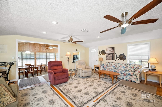 living room featuring ceiling fan, light wood-type flooring, lofted ceiling, and a healthy amount of sunlight