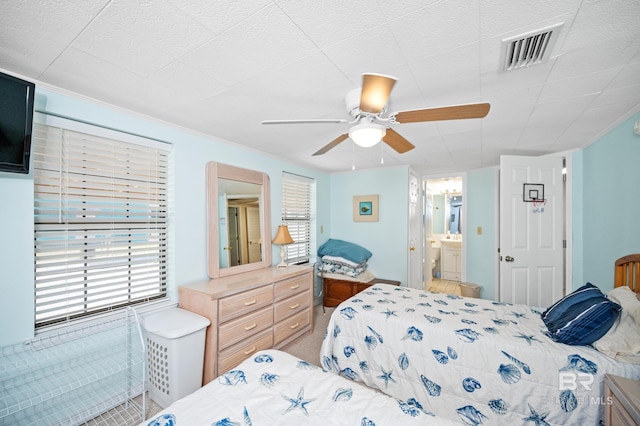 bedroom with ceiling fan, carpet flooring, and ensuite bath