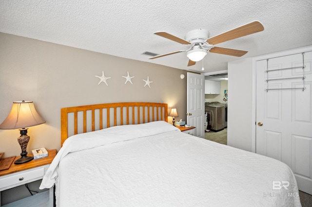 bedroom featuring ceiling fan, independent washer and dryer, a closet, and a textured ceiling