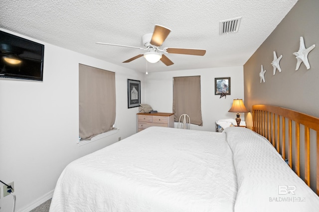 bedroom with ceiling fan and a textured ceiling