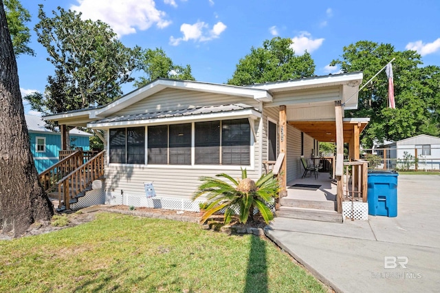 view of front of property with a sunroom and a front yard