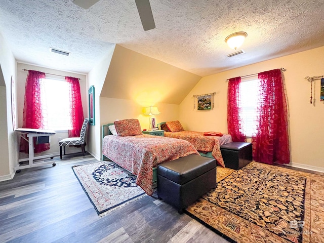 bedroom featuring wood-type flooring, lofted ceiling, a textured ceiling, and multiple windows