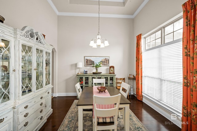 dining space featuring a notable chandelier, dark hardwood / wood-style floors, ornamental molding, and a wealth of natural light