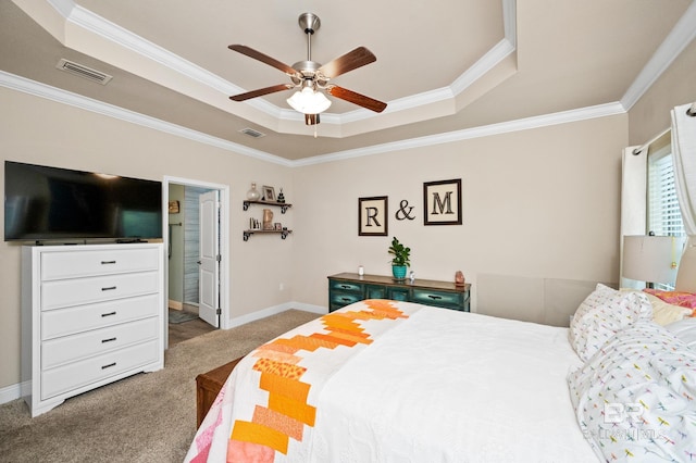 carpeted bedroom with ceiling fan, a raised ceiling, ornamental molding, and ensuite bathroom