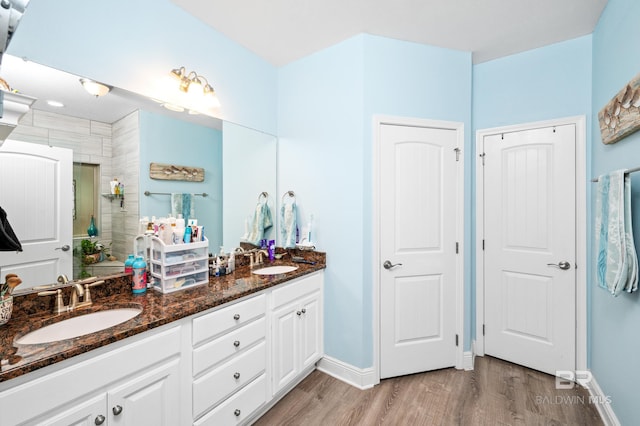 bathroom with hardwood / wood-style flooring, vanity, and a shower