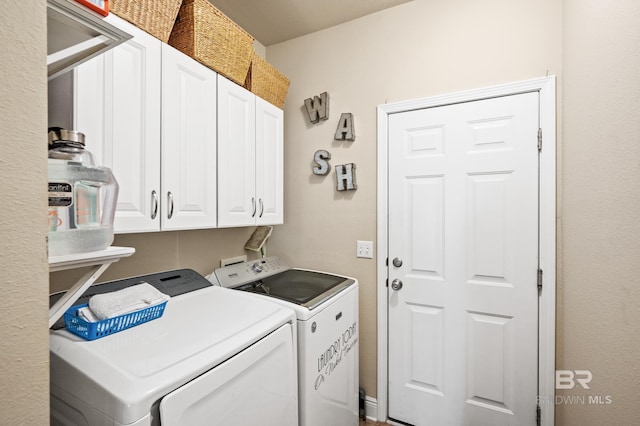 clothes washing area featuring washing machine and clothes dryer and cabinets