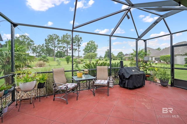 view of patio with glass enclosure and area for grilling