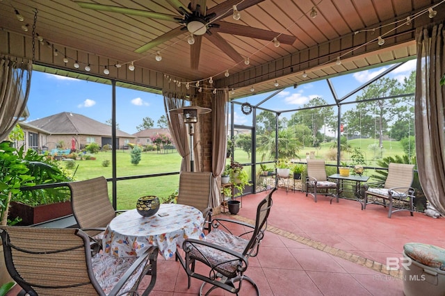 sunroom featuring ceiling fan and wooden ceiling