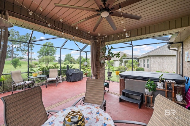 view of patio / terrace with ceiling fan, a grill, a lanai, and a hot tub