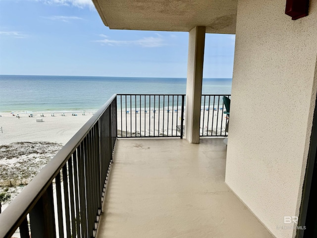 balcony featuring a beach view and a water view