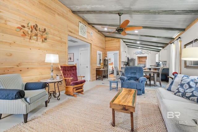 living room with vaulted ceiling with beams, ceiling fan, and wood walls