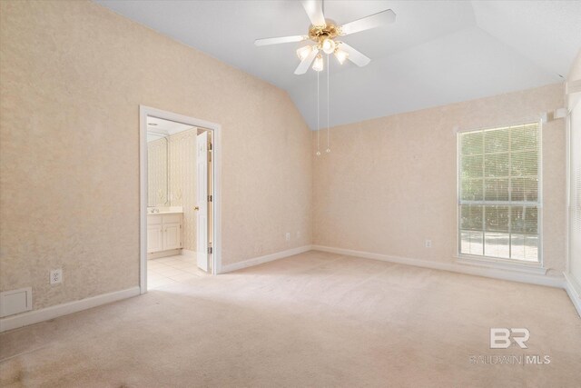 carpeted spare room featuring ceiling fan, visible vents, vaulted ceiling, and baseboards