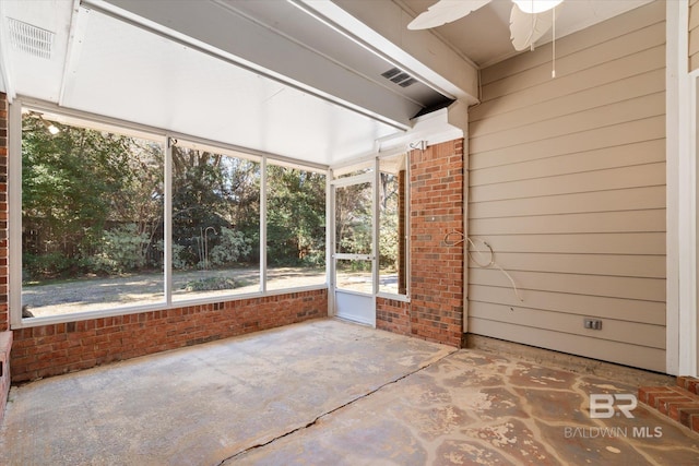 unfurnished sunroom with a ceiling fan and visible vents