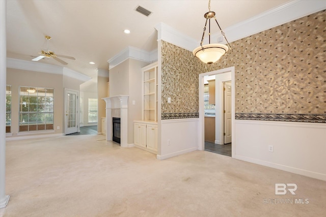 unfurnished living room with a glass covered fireplace, crown molding, and light colored carpet