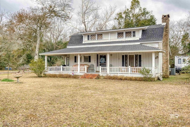 view of front of home with a front lawn, central air condition unit, and a porch