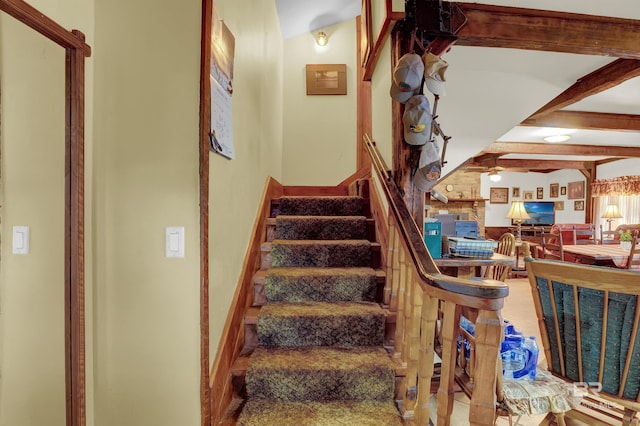 stairway featuring beamed ceiling