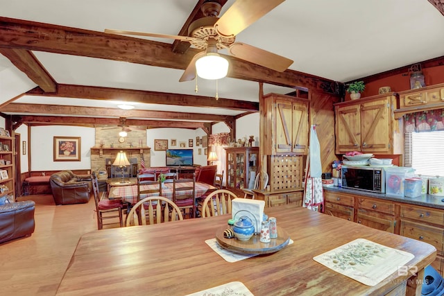 dining room featuring ceiling fan and beam ceiling