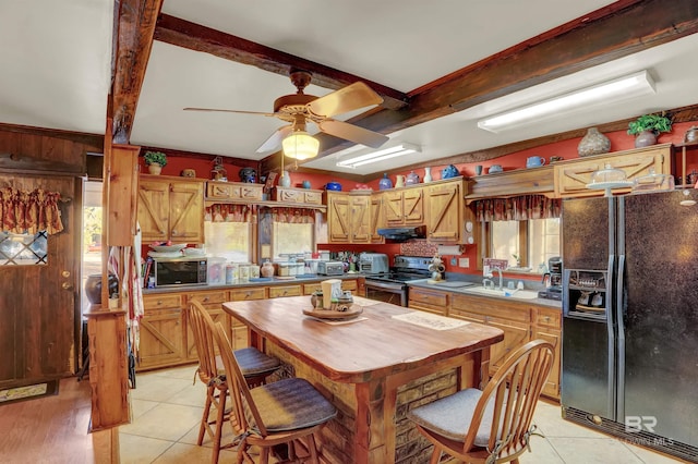 kitchen featuring light tile patterned flooring, ceiling fan, beam ceiling, and black appliances