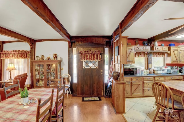 dining area featuring beam ceiling and light hardwood / wood-style floors