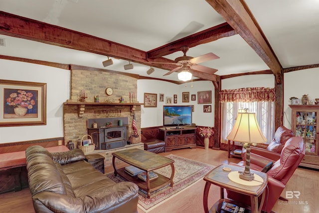 living room with ceiling fan, beam ceiling, and light hardwood / wood-style floors