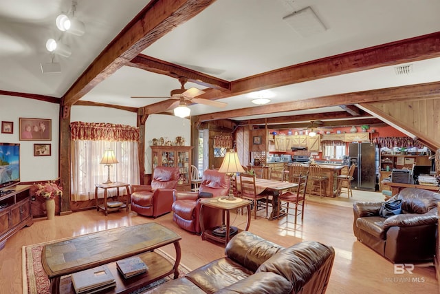 living room with beamed ceiling, ceiling fan, and light hardwood / wood-style flooring