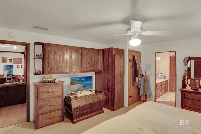 bedroom featuring light carpet, connected bathroom, and ceiling fan