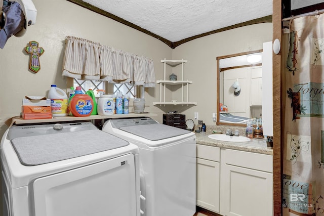 clothes washing area featuring ornamental molding, sink, a textured ceiling, and washer and clothes dryer