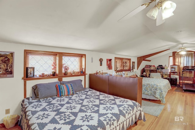 bedroom with hardwood / wood-style flooring, vaulted ceiling, and ceiling fan