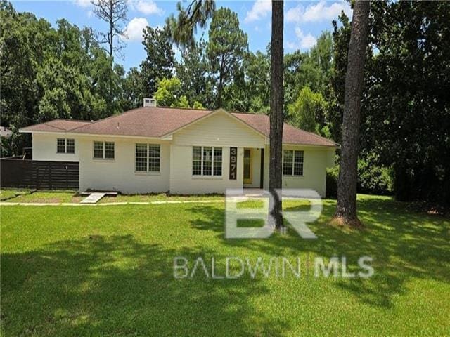 rear view of property featuring a lawn