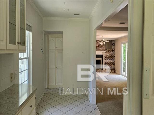 interior space featuring crown molding and light tile patterned flooring