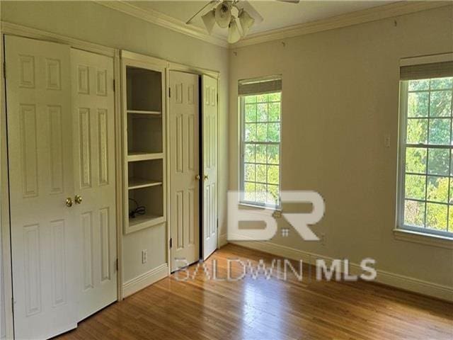 interior space with crown molding, hardwood / wood-style floors, and multiple windows