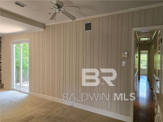 interior space with crown molding, ceiling fan, and dark carpet