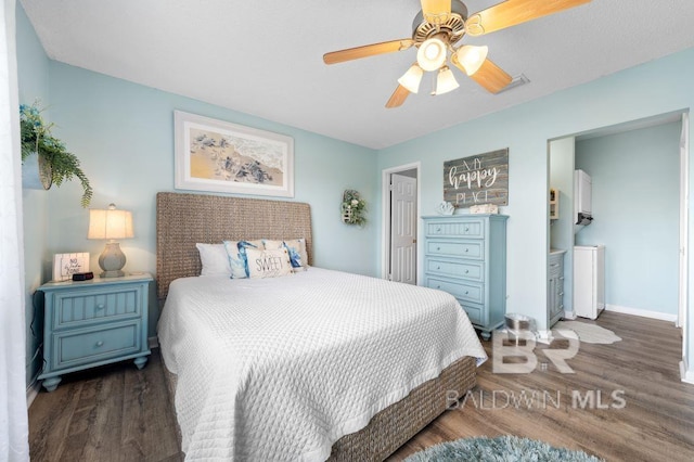 bedroom featuring a ceiling fan, wood finished floors, and baseboards