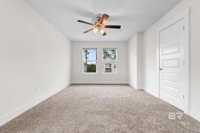 carpeted spare room with ceiling fan