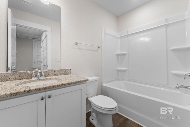 full bathroom with hardwood / wood-style flooring, vanity, shower / bathtub combination, and toilet