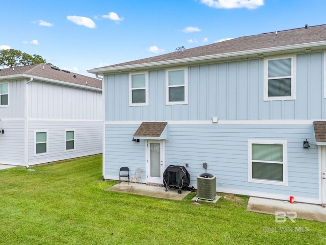 back of property featuring a lawn and central air condition unit