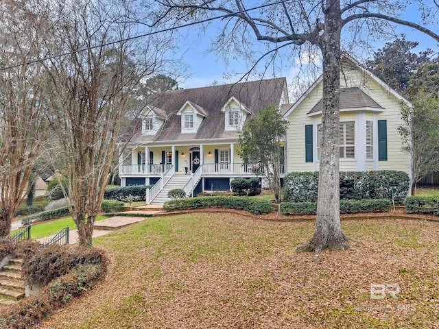 cape cod home featuring a front yard and a porch