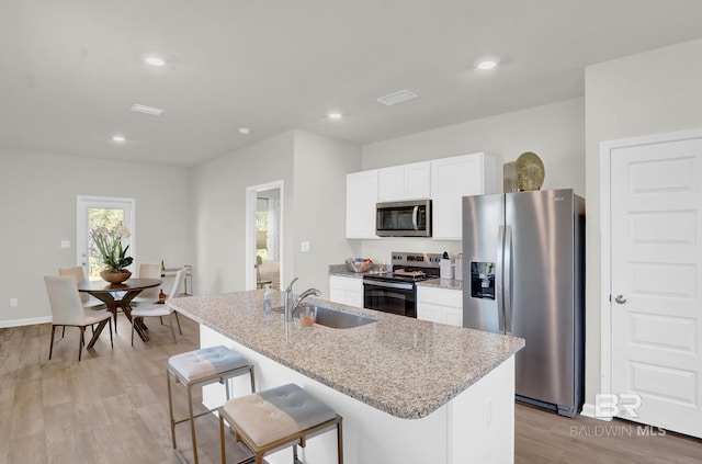 24926 Ponder Loop, Loxley, AL 36551 - kitchen with stainless steel appliances, a sink, a kitchen island with sink, light stone counters, and white cabinets