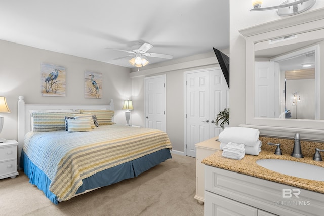 carpeted bedroom with ceiling fan and sink