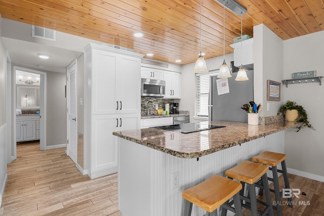 511 E Beach Blvd Unit 203, Gulf Shores, AL 36542 - kitchen featuring a kitchen bar, light wood-style flooring, visible vents, and stainless steel appliances