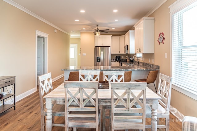 kitchen featuring light hardwood / wood-style flooring, a breakfast bar, light stone countertops, and stainless steel appliances