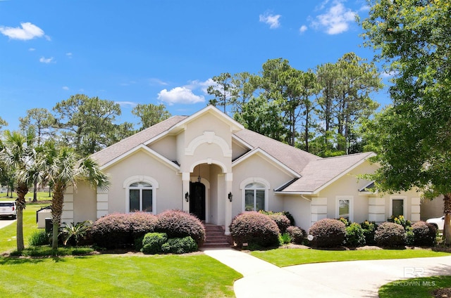 613 Wedgewood Dr, Gulf Shores, AL 36542 - mediterranean / spanish house with a front lawn, stucco siding, and roof with shingles