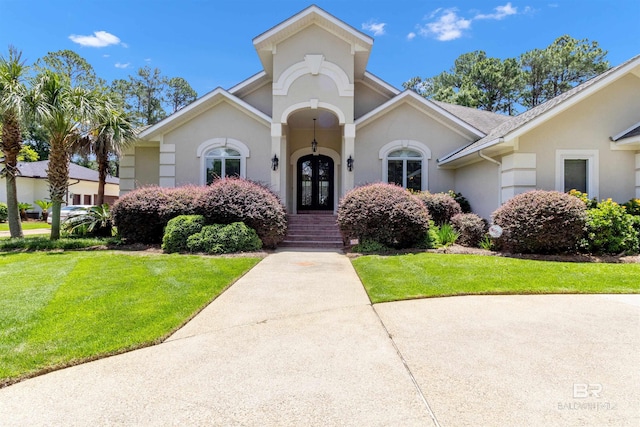 613 Wedgewood Dr, Gulf Shores, AL 36542 - mediterranean / spanish-style home featuring a front yard, french doors, and stucco siding