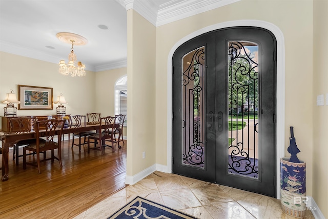 613 Wedgewood Dr, Gulf Shores, AL 36542 - entrance foyer featuring french doors, arched walkways, ornamental molding, a chandelier, and baseboards