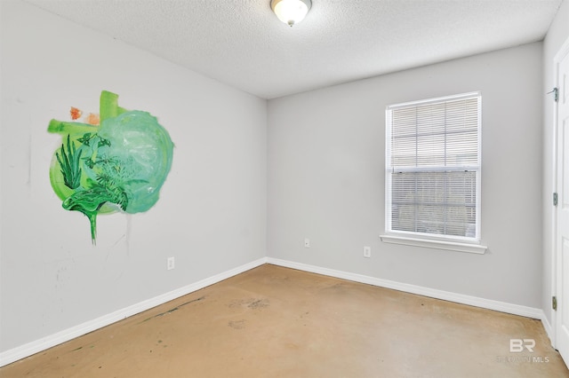 empty room with concrete floors and a textured ceiling