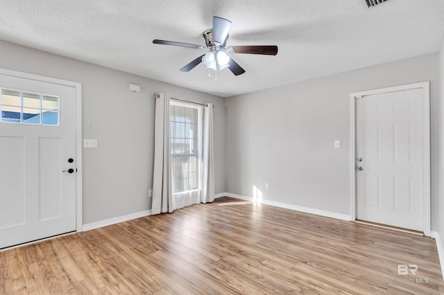 foyer entrance featuring ceiling fan, light hardwood / wood-style floors, and a textured ceiling